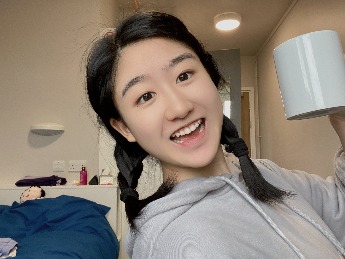 student smiling, holding a mug