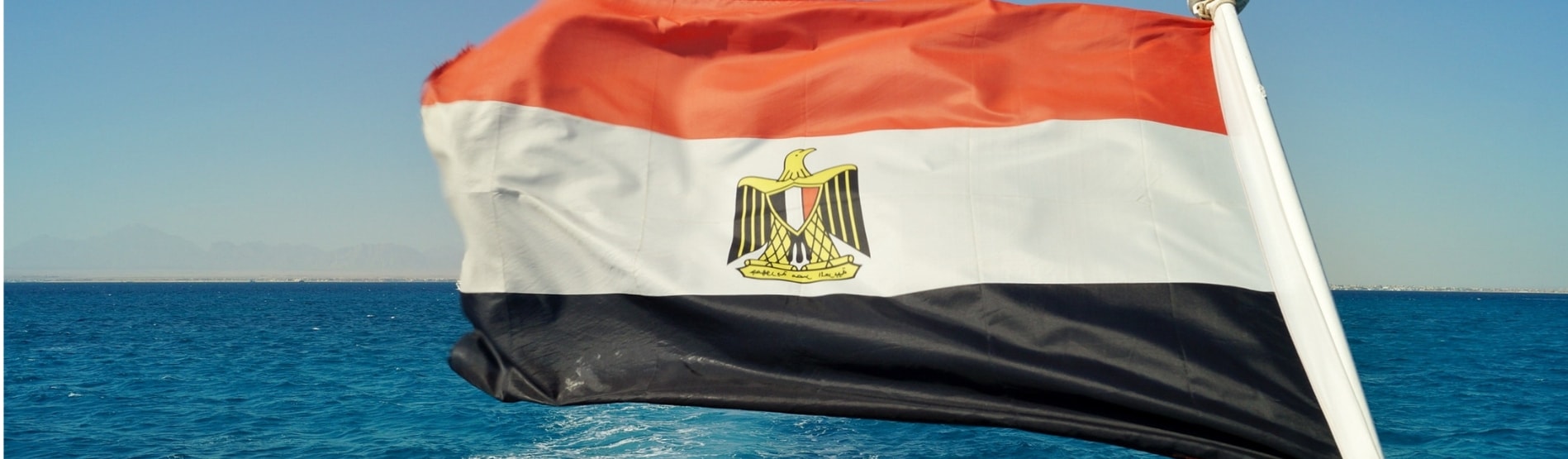 Egyptian Flag blowing in the breeze over the sea.