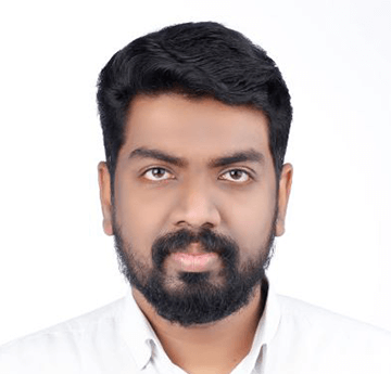 A smart portrait of Abdul who is looking straight into the camera. He is wearing a white shirt and poses on the white background. 
