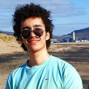 Photo of student who is from Saudi Arabic wearing sunglasses on the beach