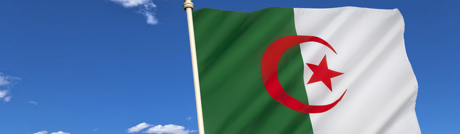 Algerian flag on the background of the blue sky