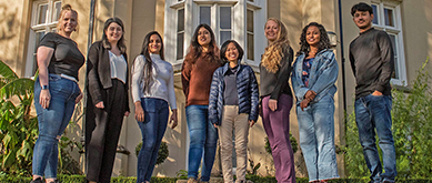 Student smiling at camera in front of Singleton abbey