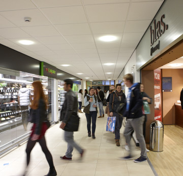 Students walking by supermarket.