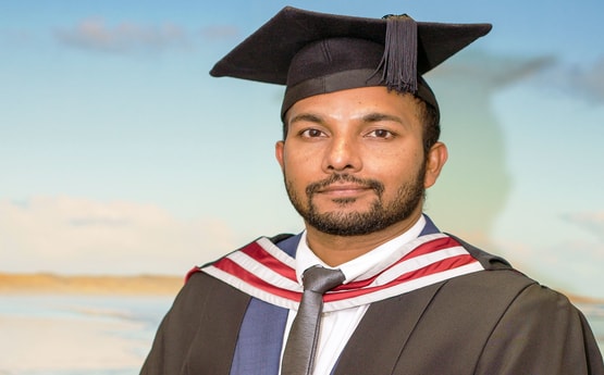 Image of recent graduate Abdulla in his graduation robes