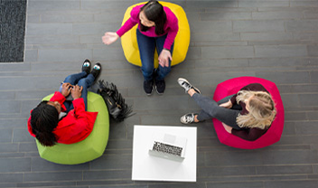 A bird's eye view of a group of women having a discussion on comfy chairs