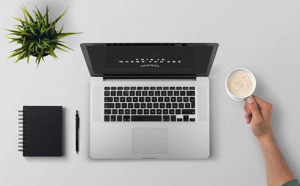 A laptop, coffee cup and book