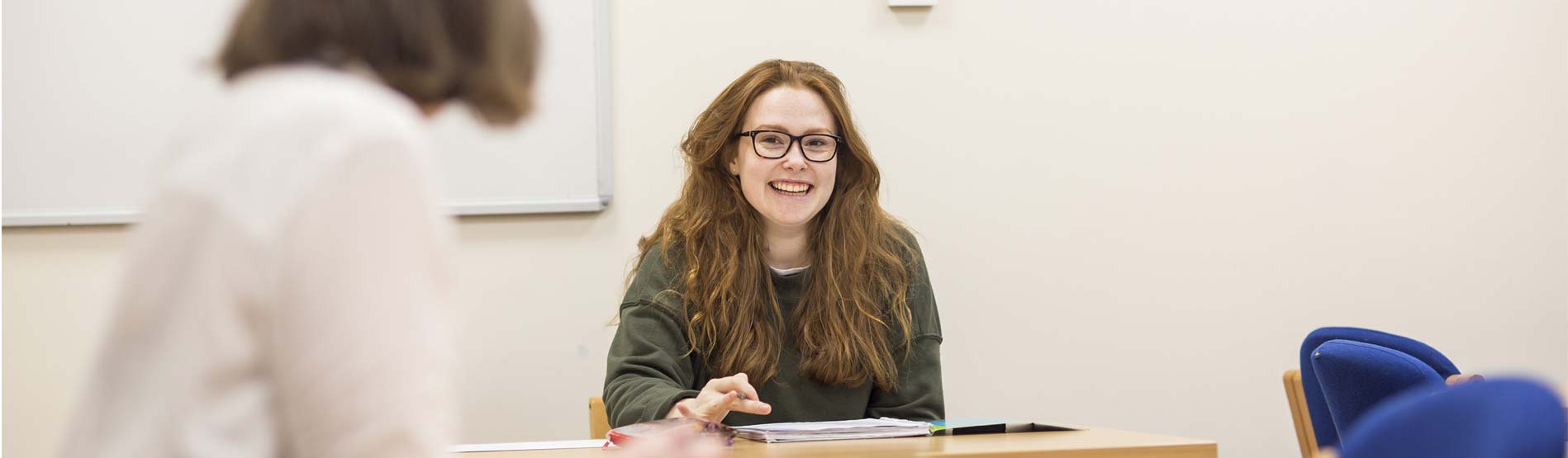 a smiling student talking to a lecturer