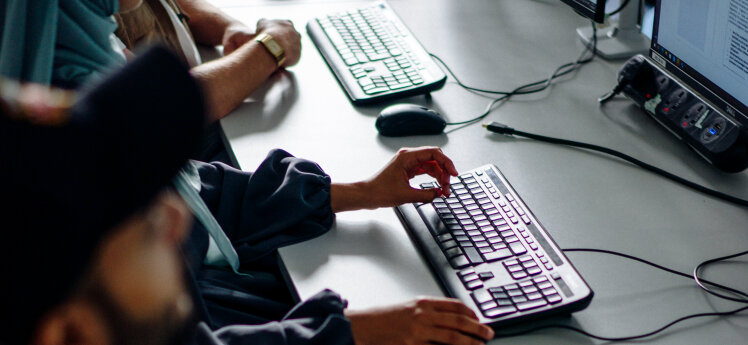 Students typing on keyboards to PCs.