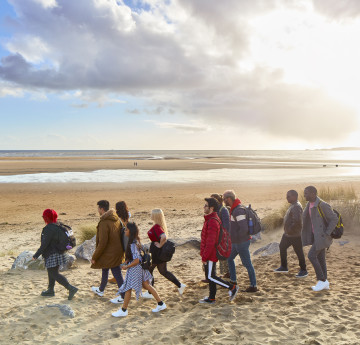 Students walking through the dunes to the beach