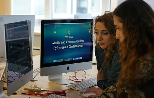 Students studying in front of macs
