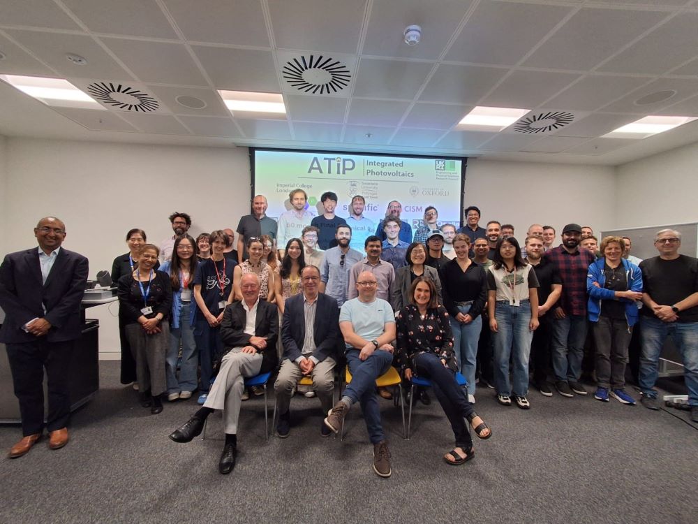 A group of about 40 people in a conference room smiling at the camera