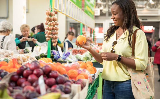 Student picking an orange at Swansea Market 