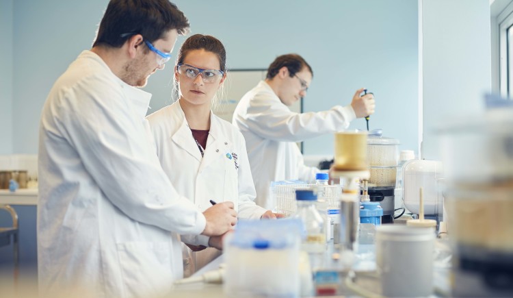 Group of scientists in white coats conducting an experiment