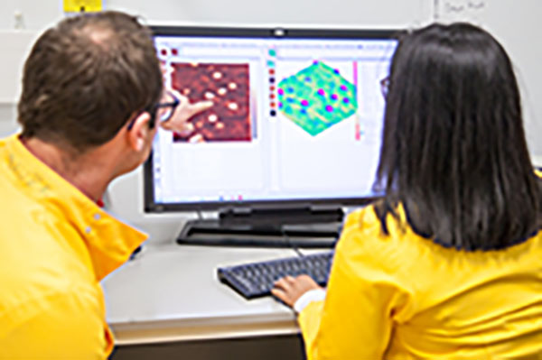 Student and lecturer looking at computer screen 