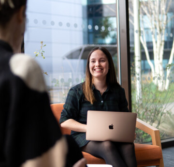 Student sat with a laptop on her lap