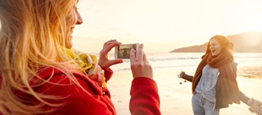 Image of graduates taking a photograph on the beach