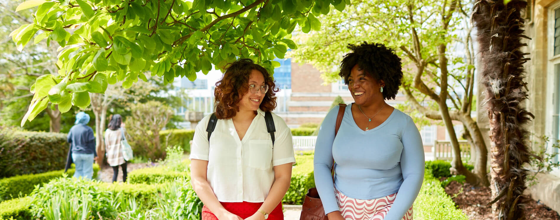 Two students smiling and walking through Singleton campus