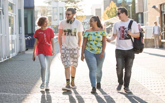 4 students walking along the mall at Swansea University
