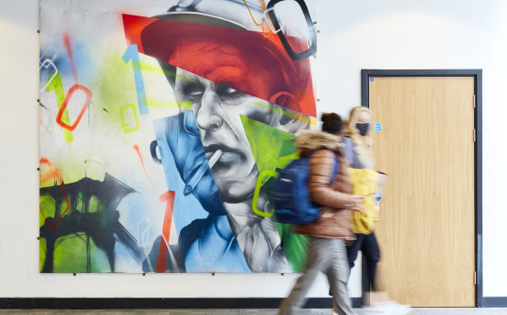 Students walking past artwork on campus