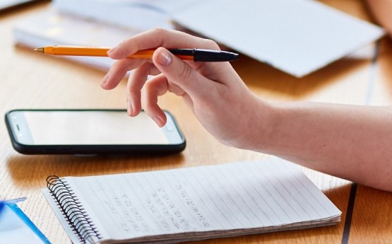 A person writing on a notepad