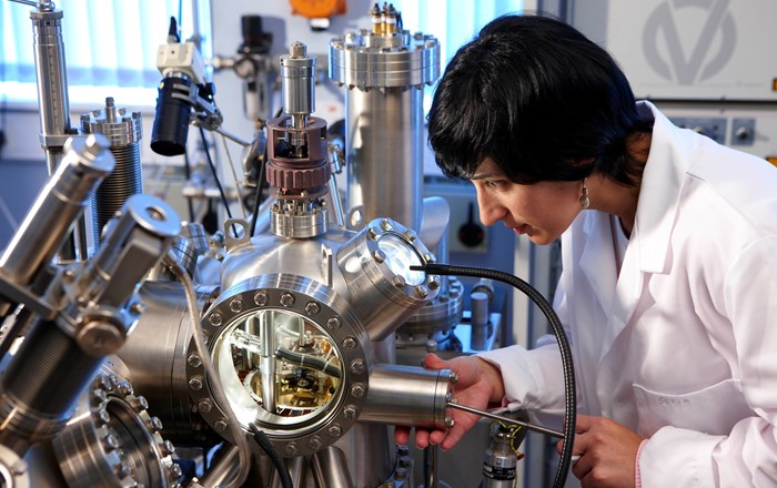 A woman looking at a mass spectrometer 