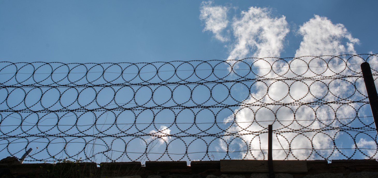 Barbed wire on prison wall: the impact of Covid restrictions on prisoners and prisons is to be examined in a new Swansea-led research project