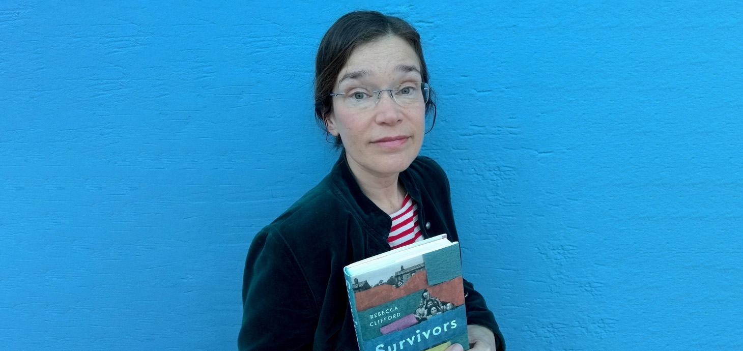 Dr Rebecca Clifford holding a copy of Survivors: Children’s Lives After the Holocaust 