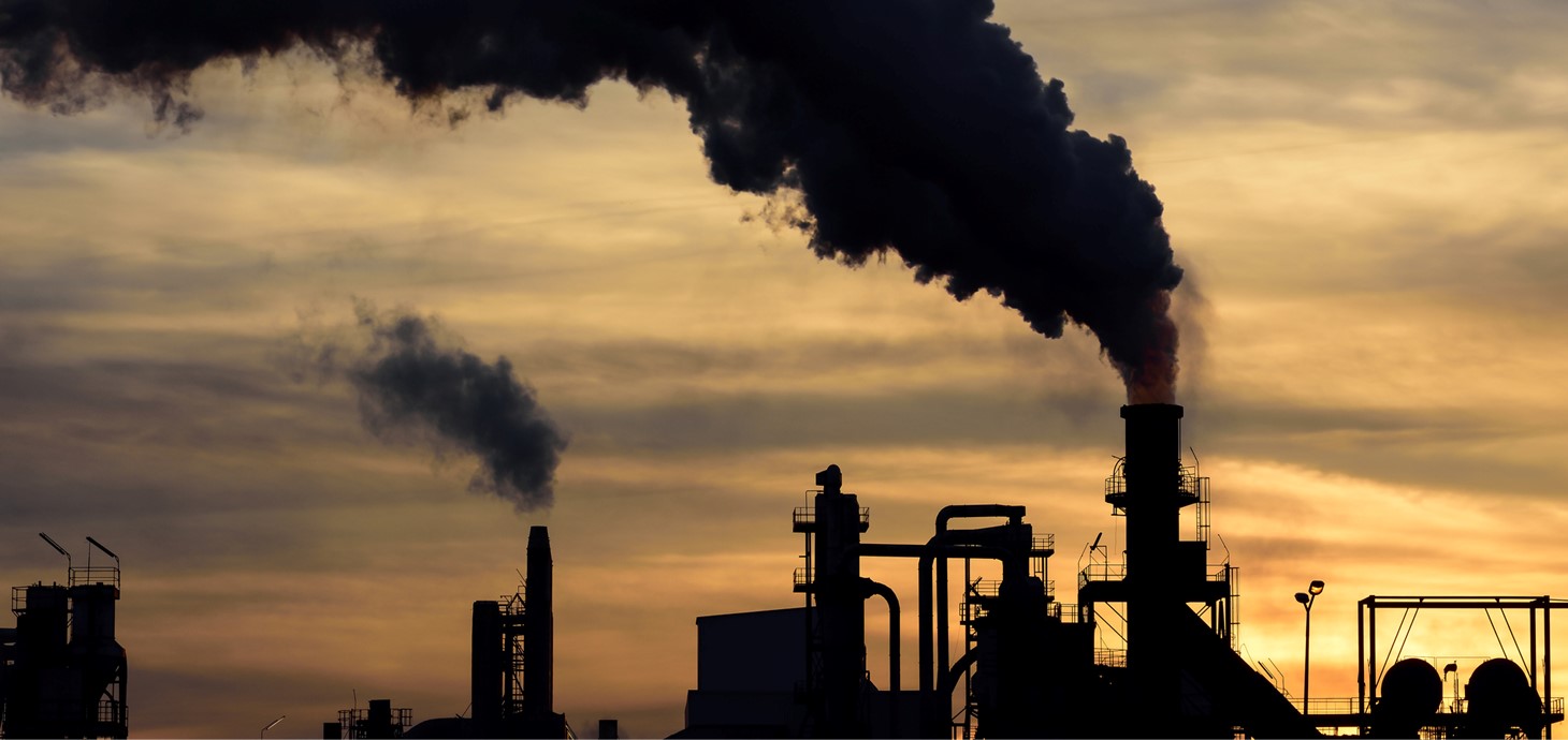 Industrial site with smoke billowing into atmosphere.