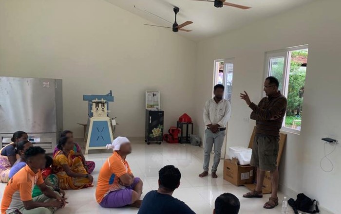 People from Khuded in a training session inside the new Active Building with a speaker from local community organisation Keshav Shrusthi, partners of the Swansea-led SUNRISE team. In the background are the new freezer, flour mill and rice husking machine powered by solar energy 
