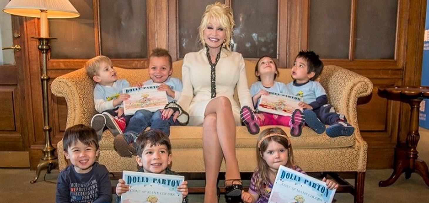 Dolly Parton with children and books; the Imagination Library has given more than 185 million books to children, and the Swansea research is the largest survey of its effectiveness ever carried out. Credit: Dollywood Foundation UK