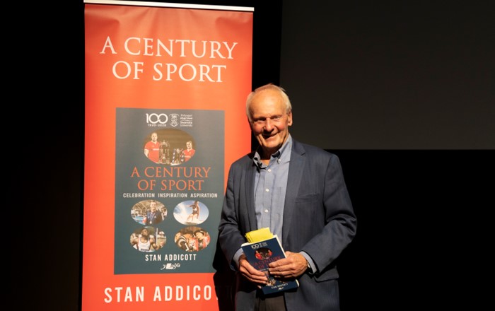 Stan Addicott holding a copy of A Century of Sport