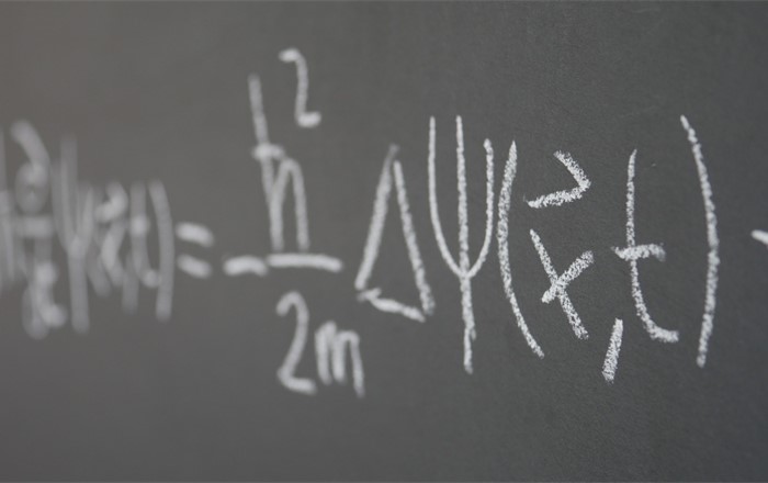 A mathematical equation written in chalk on a blackboard 