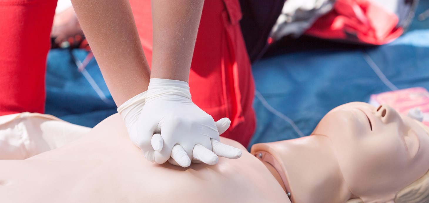 A person performing CPR on a manikin