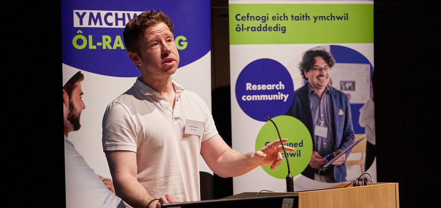 Eilian Richmond stood at a lectern, delivering his three-minute thesis