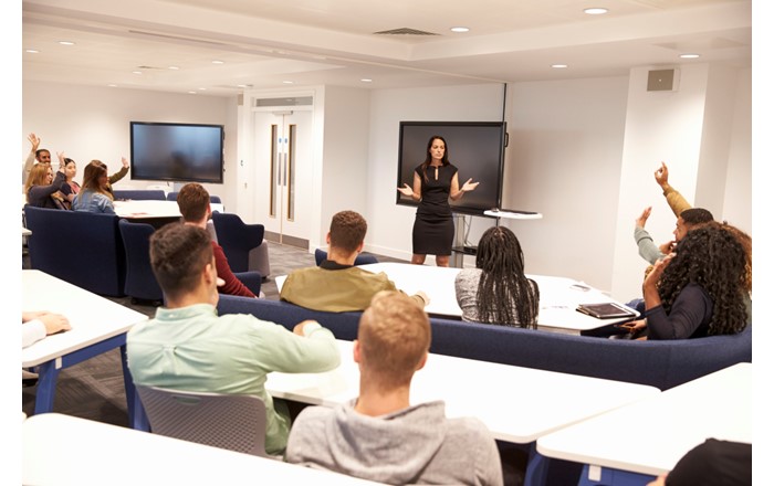 A woman teaching students in a lecture theatre