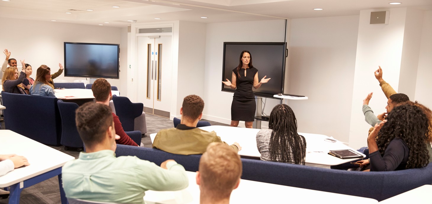 A woman teaching students in a lecture theatre