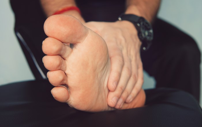 Man massaging a bare foot