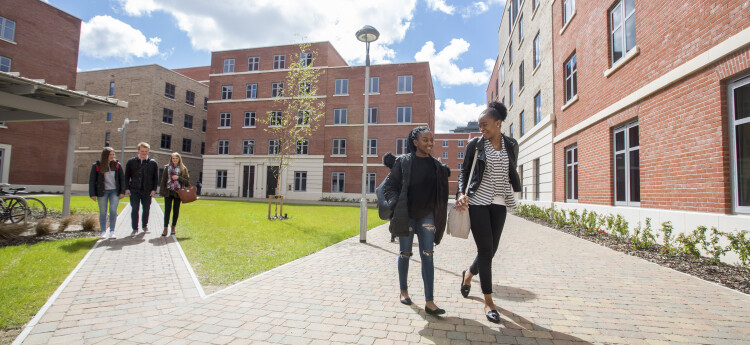 Students walking outside accommodation buildings on the Bay Campus