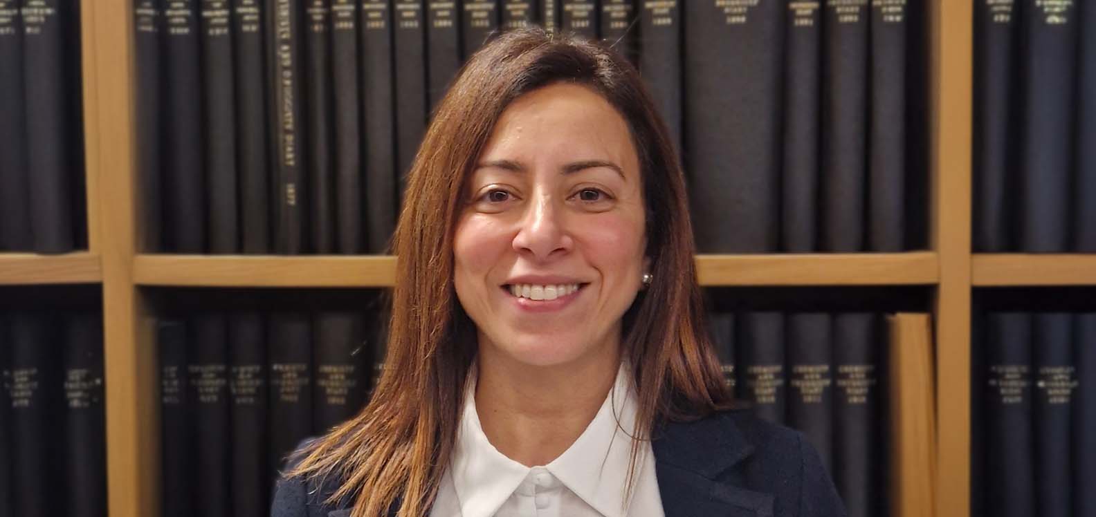 Head and shoulders of a woman in front of a bookcase