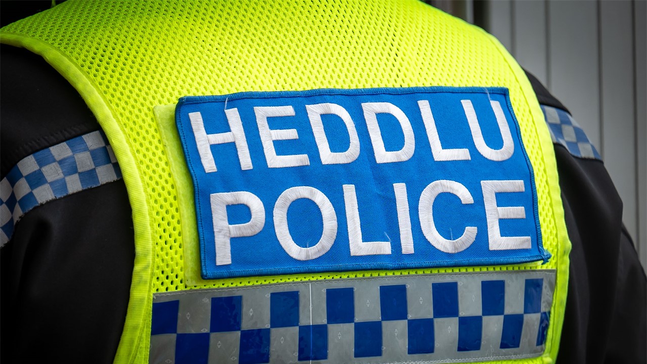 Bilingual police badge on back of high-vis jacket