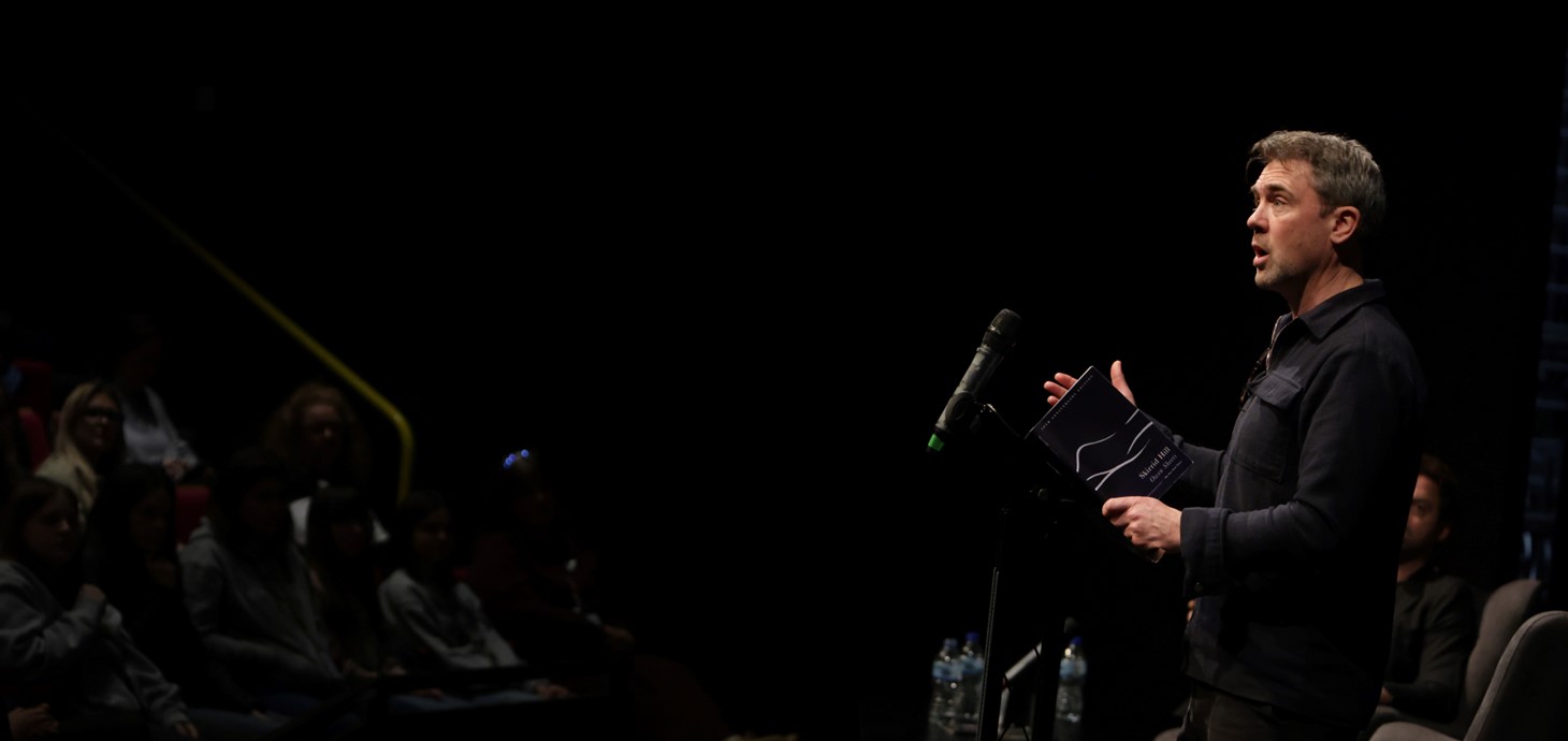 Man standing at lectern addressing an audience