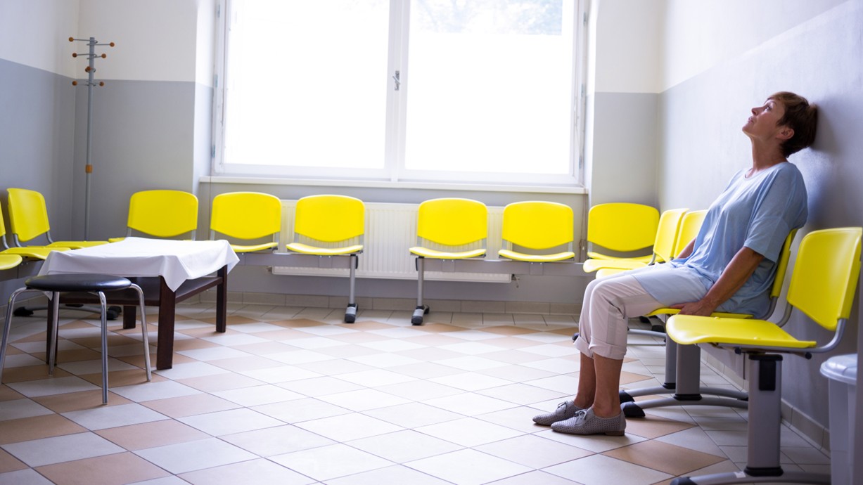 An older female patient sitting alone in the waiting room of a hospital. Credit: wavebreakmedia | Shutterstock.