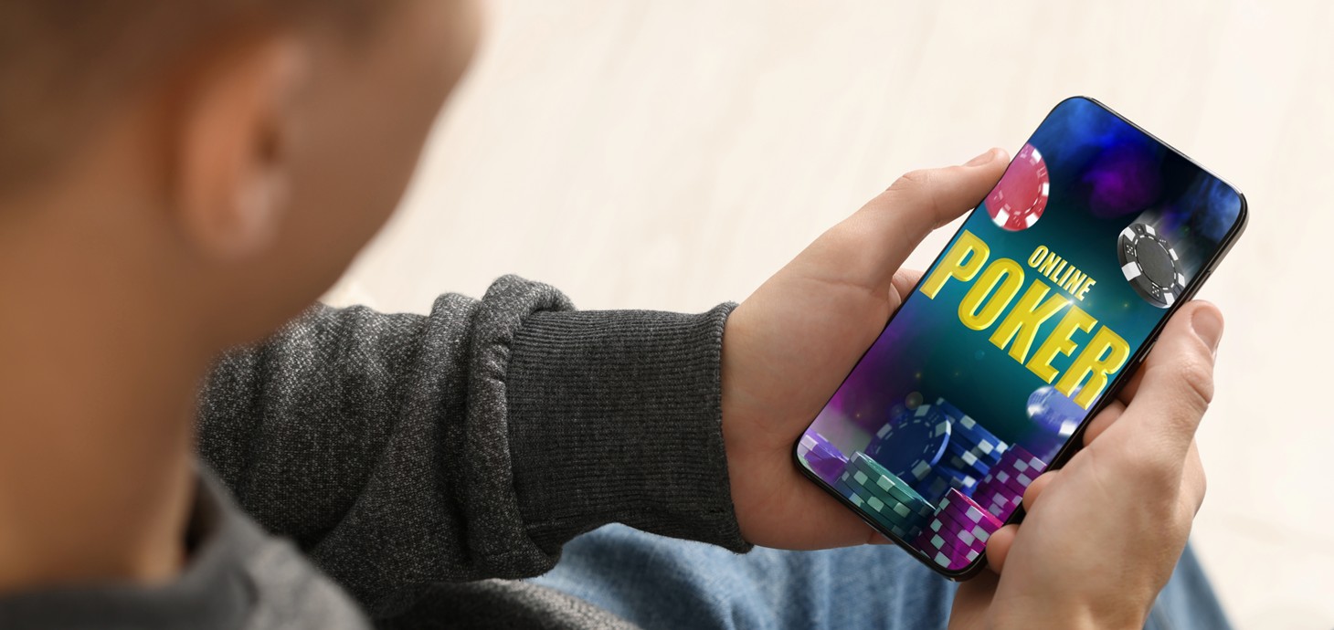 A close-up of a man using a mobile phone to play online poker