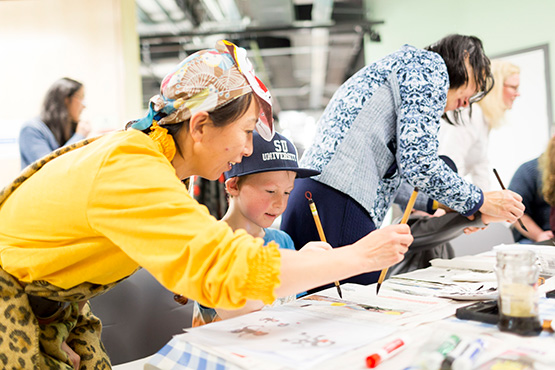 Lady and young boy painting together in a family activity