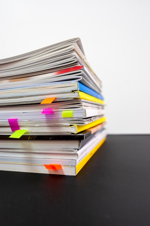 stack of colourful papers on a desk 