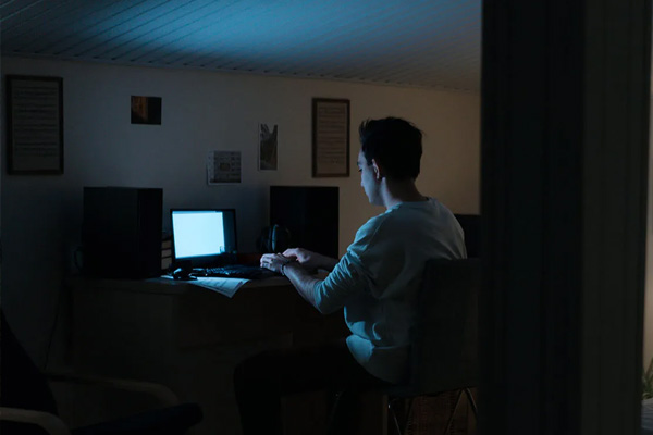 Man in the dark on his computer
