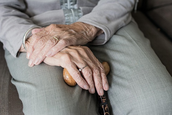 older woman's hands folded on her lap