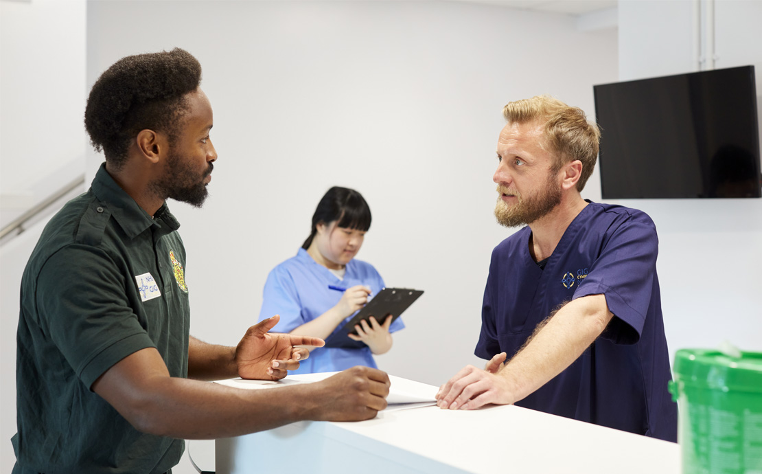 Two men and a woman in medical uniforms talking to each other 