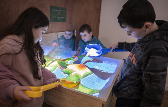 Children playing with a science exhibit