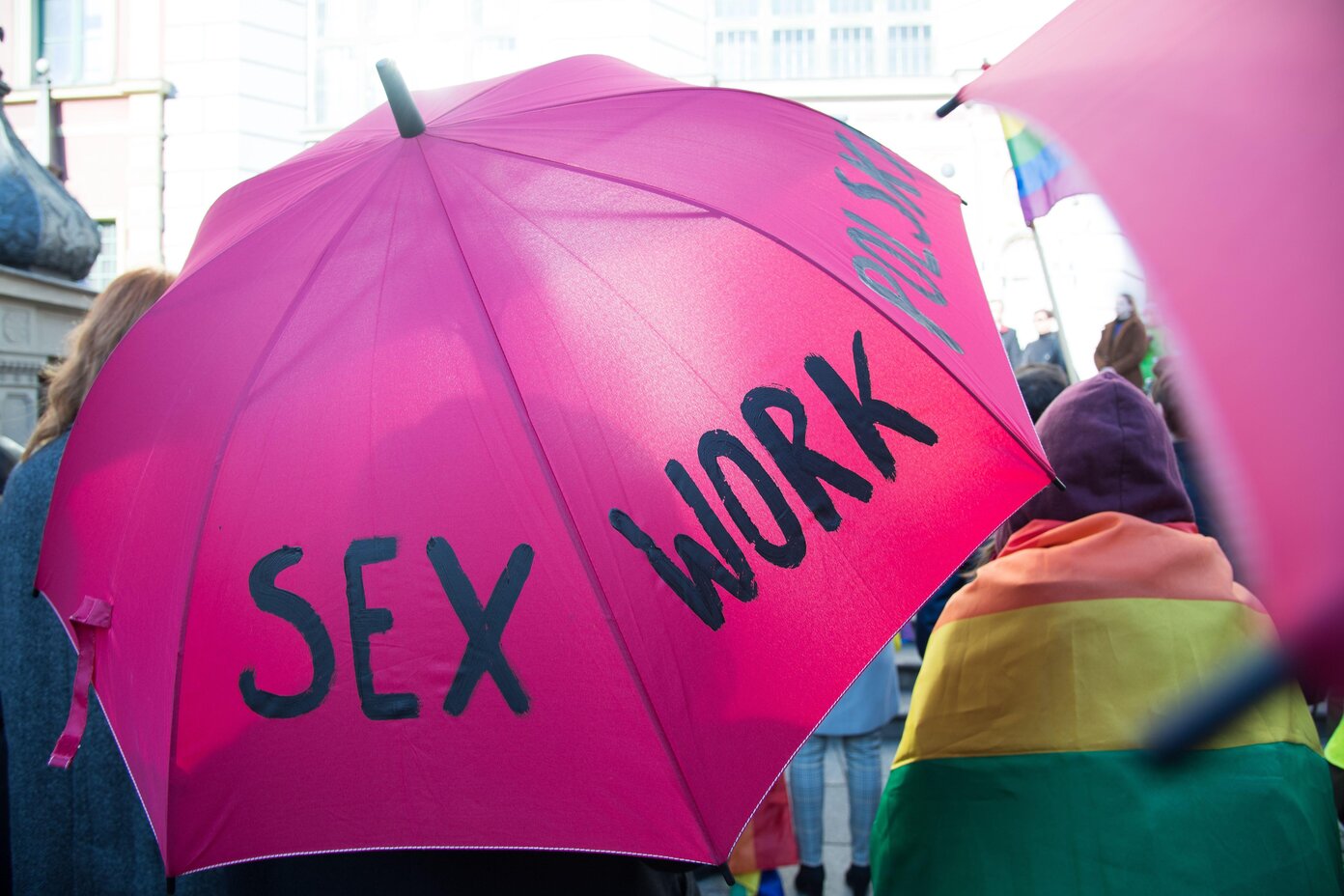 Pink umbrella with the words sex work on